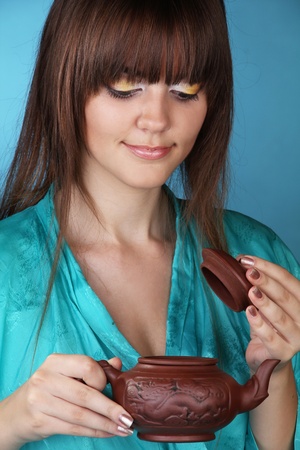 Tea ceremony with beautiful young woman on blue backgroundの写真素材