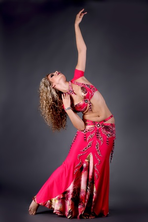 Beautiful exotic belly dancer woman posing on black backgroundの写真素材