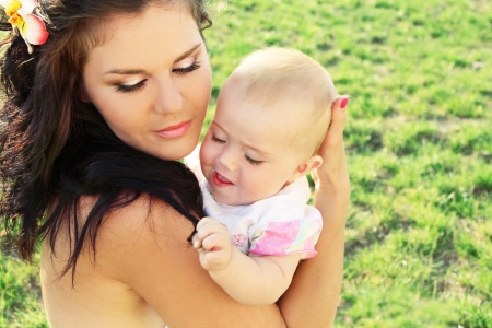 Beautiful mother with baby, outdoors portraitの写真素材
