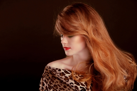 Long Red Hair. Beautiful woman portrait on black backgroundの写真素材