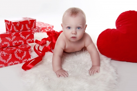 Lovely baby with Valentine's heart and gifts boxes over whiteの写真素材