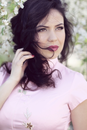Beautiful brunette woman in cherry blossom branch,  springの写真素材