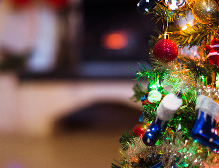 Xmas tree with Christmas present ornaments over bokeh holiday background.