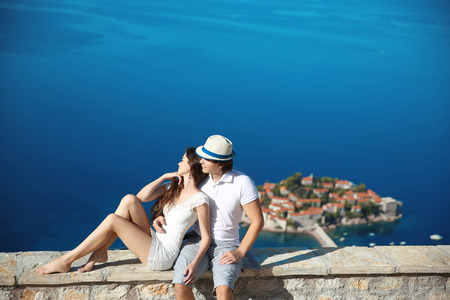 Romantic young couple in love over sea shore above Sveti Stefan island in Budva, Montenegro. Travel. Vacation. Family.の写真素材