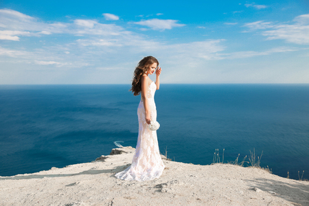 Beautiful bride in wedding dress outdoors photo. landscape background.