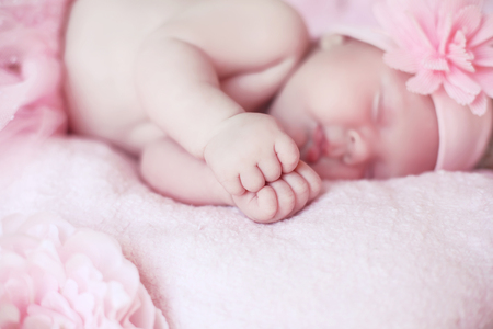 Portrait of adorable sleeping baby girl over pink, infant child.の写真素材