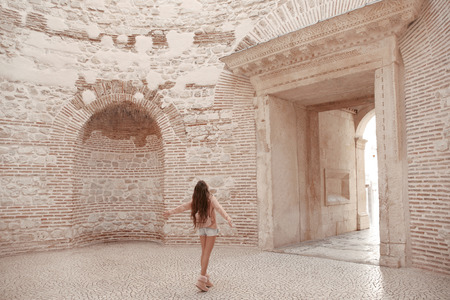Girl traveller enjoying sightseeing interior door vestibule of the Diocletian's palace in old city center of town Split, Croatia.  Ancient roman landmark. The open dome in the famous palace.の写真素材