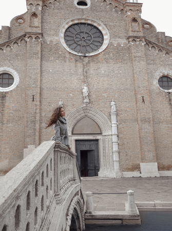 Beautiful tourist girl visiting famous landmark of Basilica Santa Maria Gloriosa dei Frari, Venice Italyの写真素材