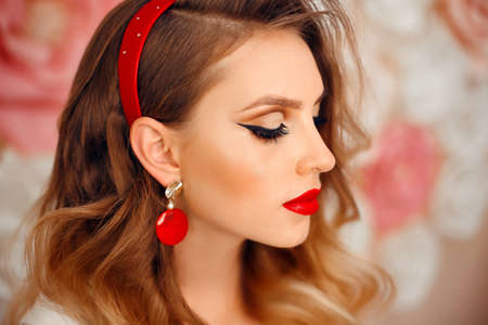 Beauty Portrait of girl with perfect makeup and red jewelry. Beautiful model woman with long curly...