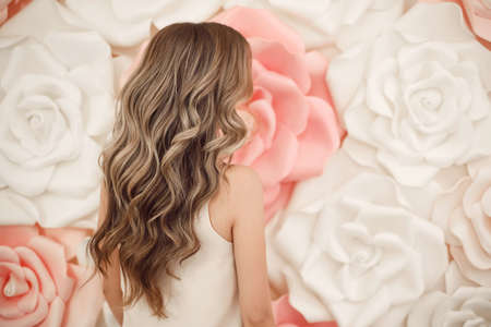 Beautiful long wavy hair style. Bride wedding hairstyle over flowers copyspace. Beauty hairdressing salon.の写真素材