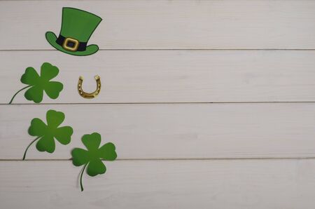 Holiday St. Patrick's Day. Green hat with clover and horseshoe on a white wooden background with...