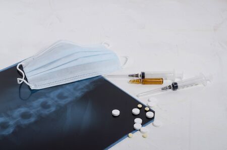 X-ray of the lungs, surgical medical mask and medication on a white background, pneumonia and...