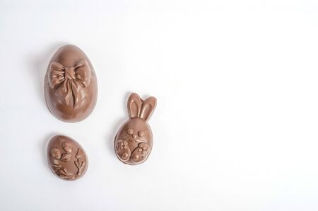 Chocolate easter eggs in the form of a rabbit and a chicken on a white background with copy space. Isolate. Happy easter. Preparing for Easter.の写真素材