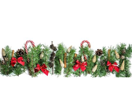 Christmas and New Year composition. Coniferous branches, pine cones, sweets and bows isolated on white background with copy space. Flat lay. View from aboveの写真素材