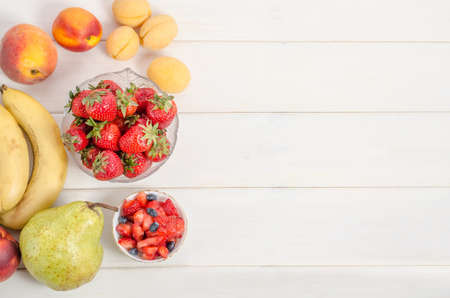 Fresh strawberries with fruits on a white background with copy space. Ingredients for fruit salad.の写真素材