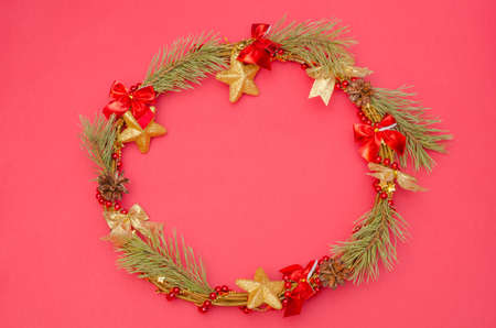 Red background with decorative Christmas wreath for Christmas and New Year with copy spaceの写真素材
