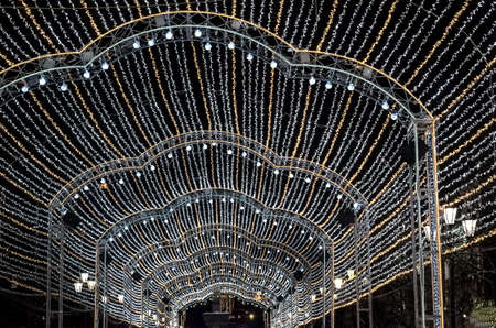 Festive decoration of the streets with glowing garlands for Christmas and New Year. Night walks