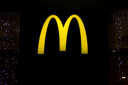 Chelyabinsk, Russia, December 31, 2019, glowing McDonald's logo on a black background, at nightのeditorial素材