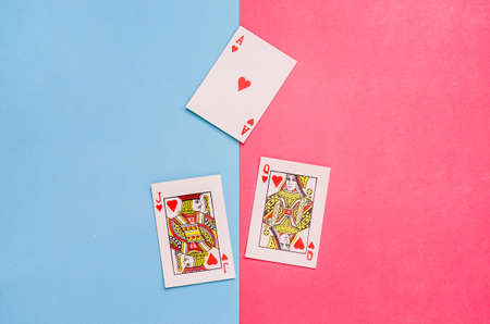 Cards - ace, queen and jack of hearts on a pink and blue background. The concept of relationships between man and woman, love.の写真素材