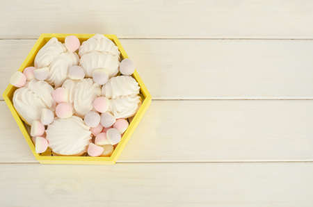 Delicate white marshmallow with marmalades on a white wooden background with copy spaceの写真素材