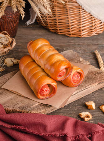 Appetizing fresh culinary pastry - sausages in pastry on wooden backgroundの写真素材