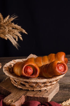 Delicious fresh culinary baked goods - sausages in dough with copy space on wooden backgroundの写真素材