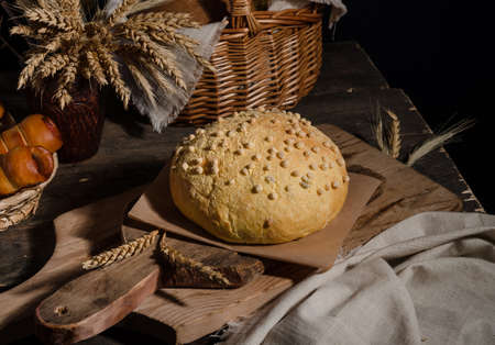 Beautiful loaf of white bread with a curly top on a wooden background