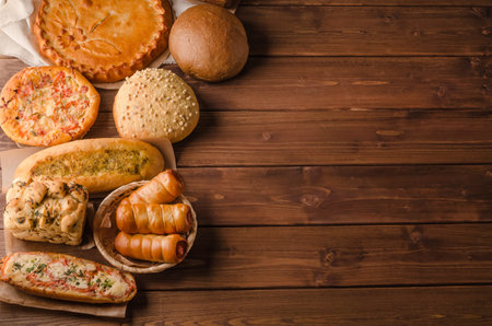 Still life with a varied assortment of bread on a wooden background with copy space, bakery banner