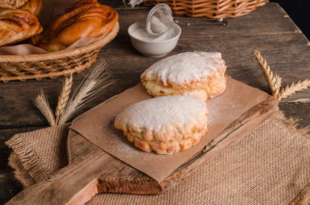 Delicious fresh culinary pastry - sweet shortbreads stuffed in powdered sugar on wooden background