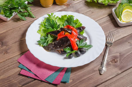 Vegetable stew of stewed eggplant and bell pepper in a white plate on a dark wooden backgroundの写真素材