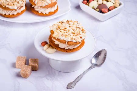 peanut cake with cream on white plate on marble background