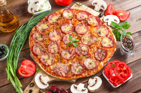 Pizza with sausage and cheese on wooden background with selective focusの写真素材