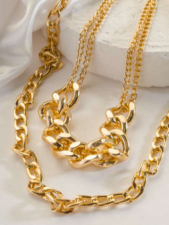 Fashion bijouterie - a large double gold chain on a white stand