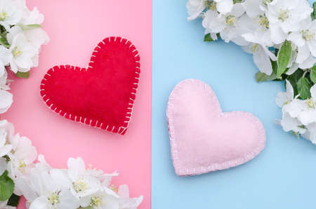 Valentine's Day card, two hearts on a pink-blue background with white flowers of an apple tree