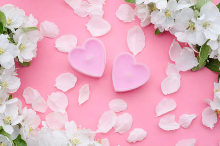 Spa treatments as a gift for Valentine's Day, banner - with candles in the form of hearts with petals on a pink background.の写真素材