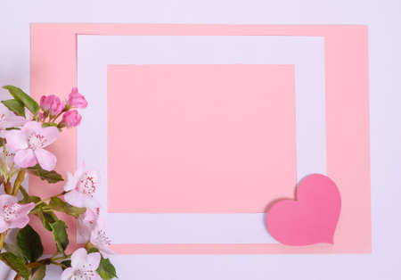 Pink background card for Valentines day with copy space, white frame with hearts and flowersの写真素材