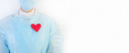 Female doctor in a protective blue suit with a red heart on a white background with copy spaceの写真素材
