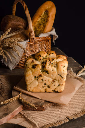 Beautiful loaf of white bread with a curly top on a wooden background