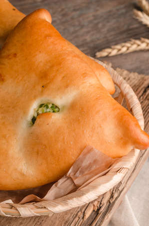 Appetizing fresh culinary pastry - pies with different fillings on a wooden backgroundの写真素材