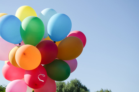 praznichny summer day against a bright blue sky colored armful of colorful inflatable ballsの写真素材
