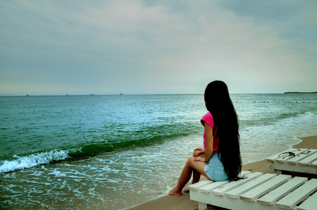 Summer girl with very long hair looking into the distance on the beach on the Black Seaの写真素材