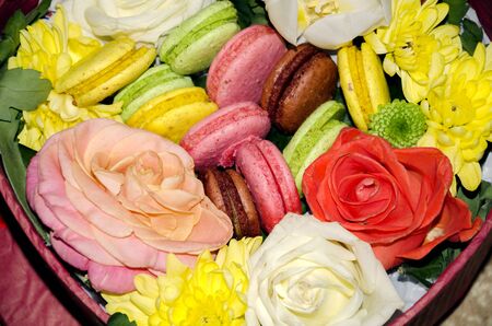Box with bright pasta macaroni and colorful flowers of roses, chrysanthemums and tulipsの写真素材