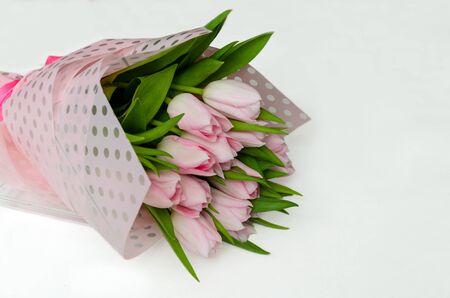 beautiful bouquet of pink tulips, flowers on a light background in a bouquet, a gift for the holiday, beautiful background, close-uの写真素材