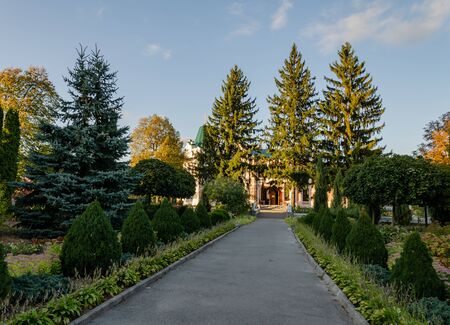 pedestrian path among trees leading to the Orthodox Church, autumn afternoon