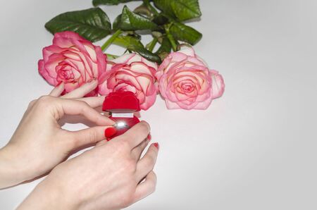 marriage proposal, a beautiful ring in a red box on a background of roses
