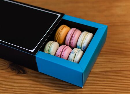 macaroni french cookies sweet and colorful, dessert in a box, on a light background, close-upの写真素材