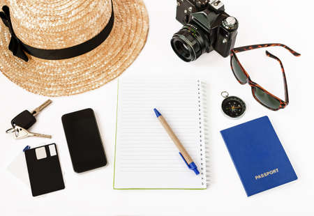 top view of notepad with pen, phone, camera, sunglasses on white backgroundの写真素材