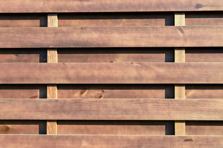 brown wood background with horizontally arranged boards, fence close-upの写真素材