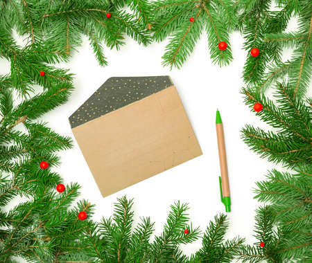 kraft paper envelope for greeting cards in christmas frame made of fir branches, christmas concept