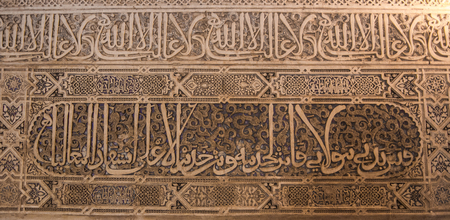 GRANADA, SPAIN - FEBRUARY 10, 2015: A close-up view to calligraphy decorated details of an archway at palace of Alhambra, Granada, Andalusia, Spain.のeditorial素材